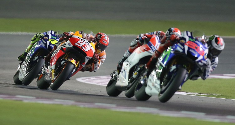 Spanish rider Marc Marquez (2L) of Repsol Honda Team competes to win third place in the Qatar Moto Grand Prix race on March 20, 2016 at the Losail International Circuit in the Qatari capital Doha. Spanish driver of Movistar Yamaha MotoGP Jorge Lorenzo won the Qatar MotoGP. / AFP PHOTO / KARIM JAAFAR